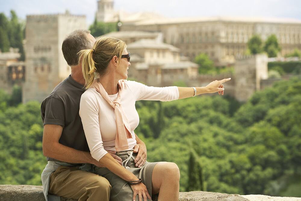 Tourist couple enjoying the view of Alhambra, Granada, Spain Tourist couple enjoying the view of Alhambra, Granada, Spain