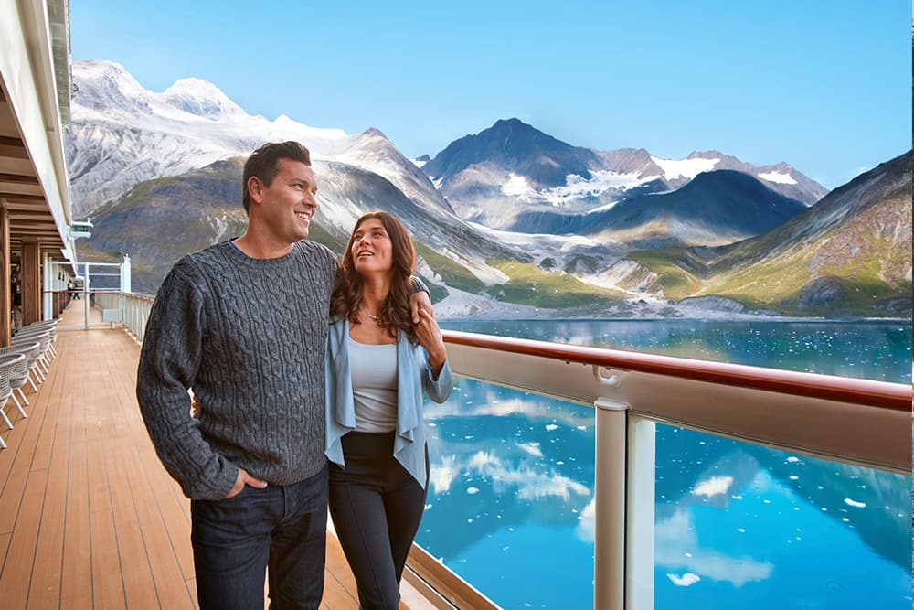 Couple on board Norwegian Bliss enjoying the view of the Alaskan waterfront