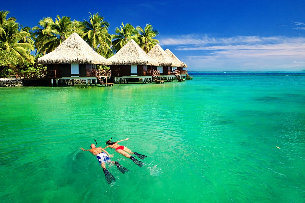 Couple snorkeling in near a lagoon in Tahiti