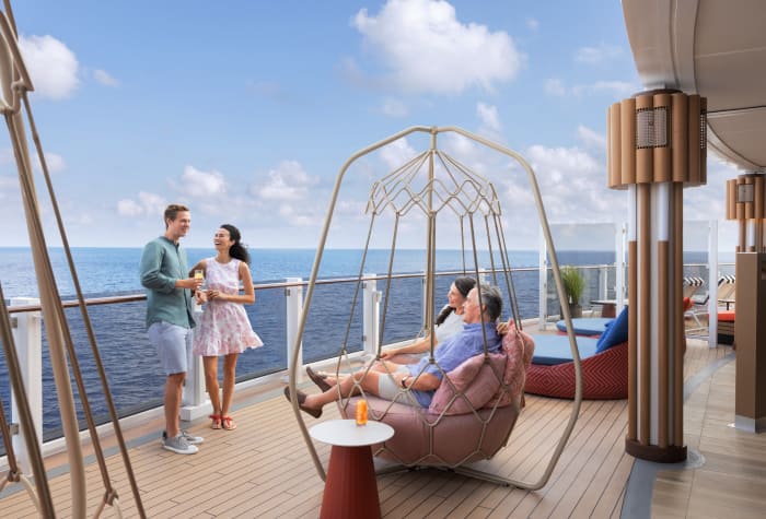 Cruisers relaxing onboard Norwegian Prima boardwalk and swings overlooking ocean
