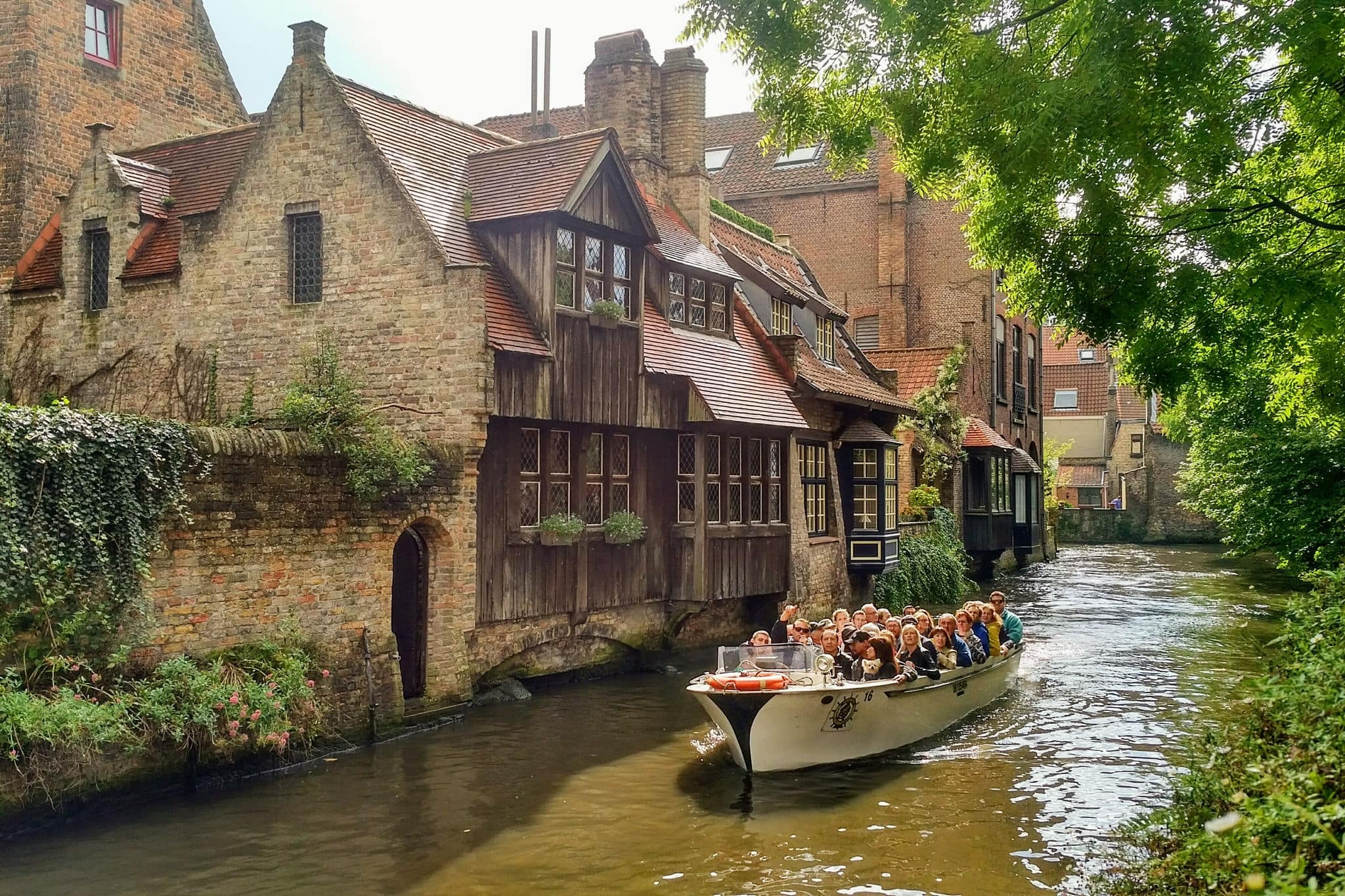 NCL-Brussels-Bruge-Zeebrugge-Cruise-Canal-Boat.jpg Brugges, Belgium - September 9, 2017: Tourists take a scenic boat tour to admire the beautiful medieval buildings along the canals of Brugges, Belgium.