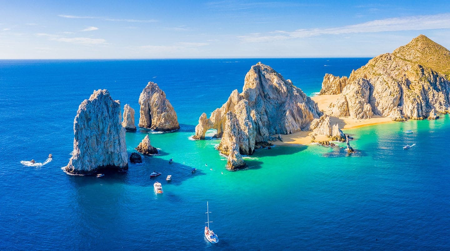 Aerial panoramic view of Lands End and El Arco at the tip of Baja California Sur, with the Cabo San Lucas, Mexico marina in the background